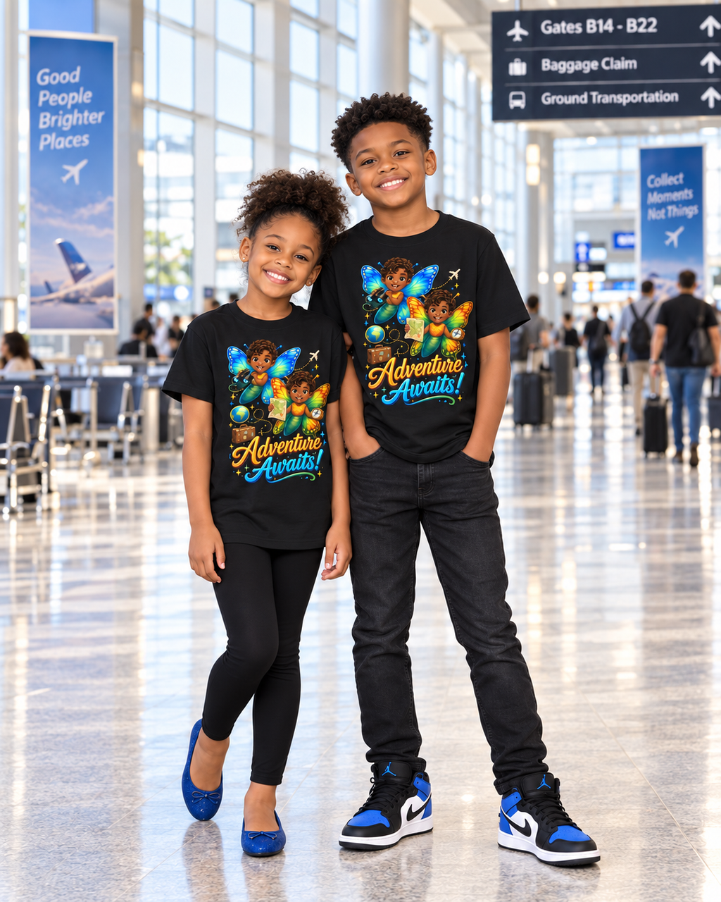 Two children standing in an airport terminal wearing matching black graphic t-shirts with a colorful 'Adventure awaits!' print and butterfly graphics.